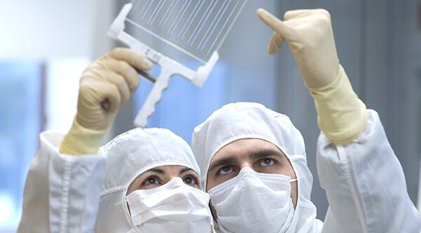 Two people viewing optical screen to highlight collaboration with customers for customized materials solutions