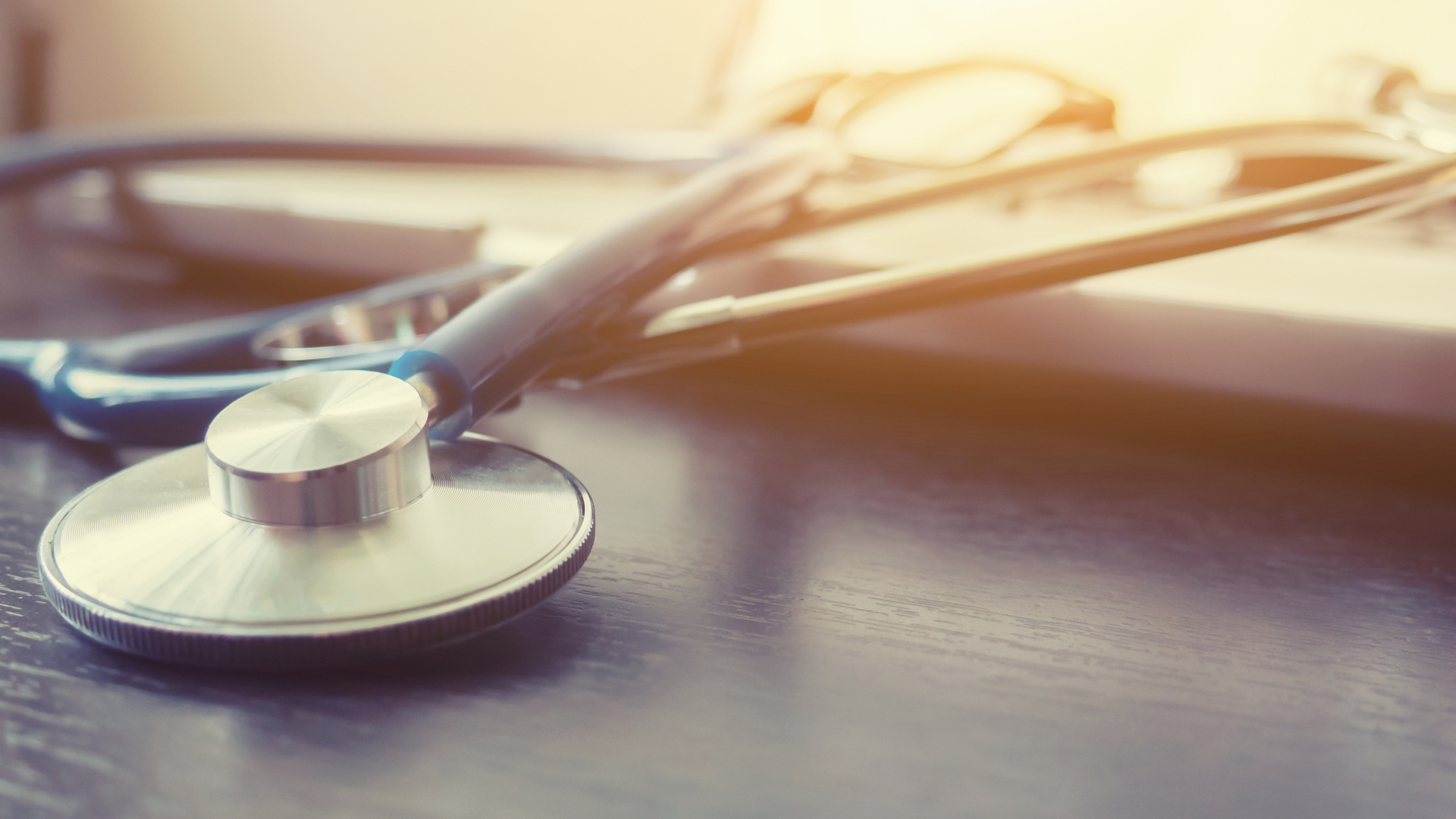 Stethoscope and laptop keyboard on desktop in hospital,relax time doctor,medical concept,selective focus,vintage color.morning light,banner