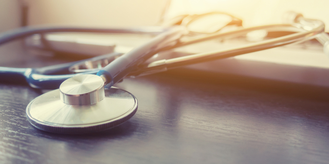 Stethoscope and laptop keyboard on desktop in hospital,relax time doctor,medical concept,selective focus,vintage color.morning light,banner