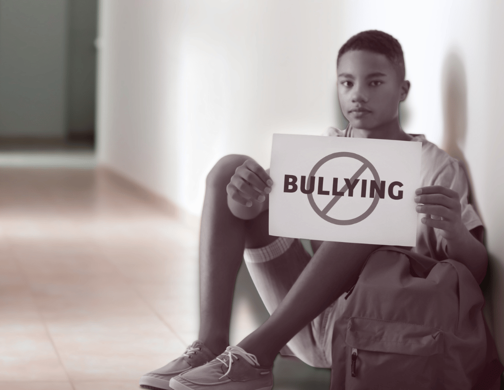 Teen boy holding a 'no bullying' sign.