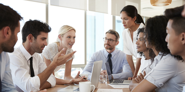 Group Of Businesspeople Meeting Around Table In Office