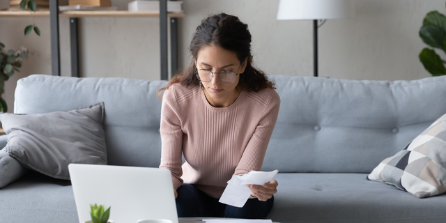 Serious female manage family finances using laptop