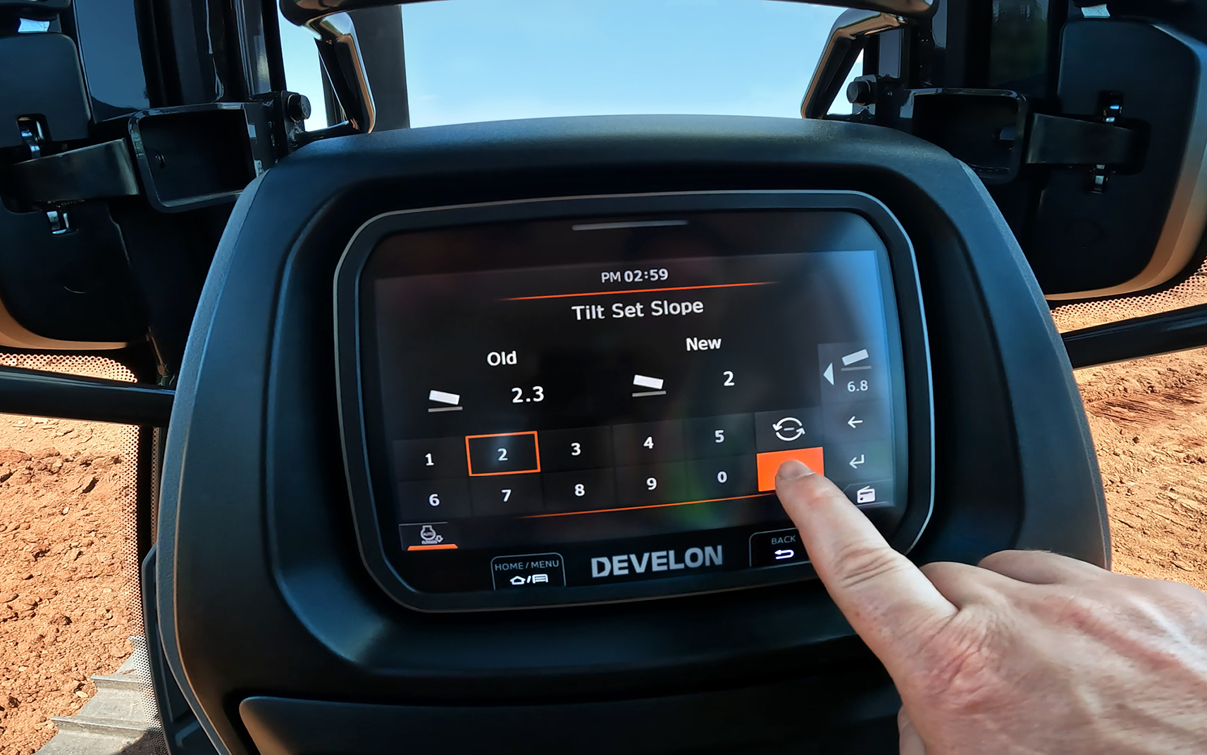 An operator activates an in-cab 2D grade control system, which comes standard for DEVELON DD100 and DD130 dozers.