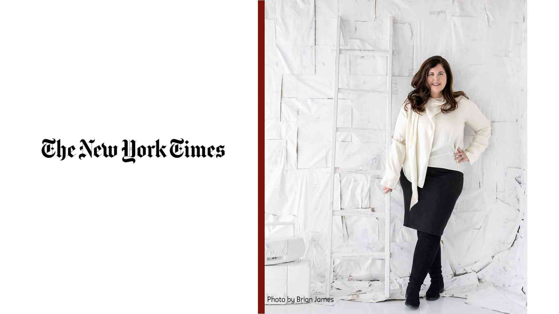 Photo of Lisa Unger next to a white ladder in front of a wall made up of rectangular pieces of painted white canvas pieced together. A boom box sits on a box next to the ladder--both items painted white.