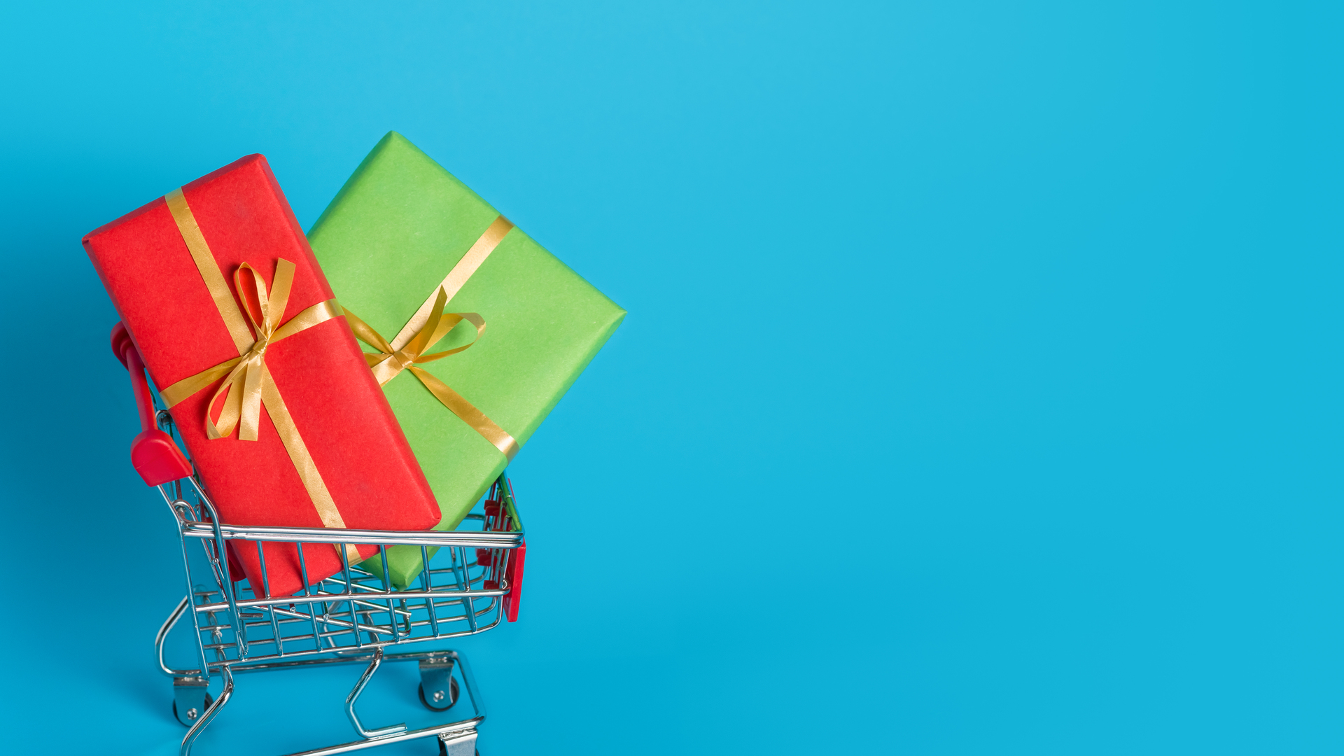 Buy holiday gifts in stores for Valentines Day or International Womens Day on March. Boxes in multi-colored paper with ribbons in a shopping cart