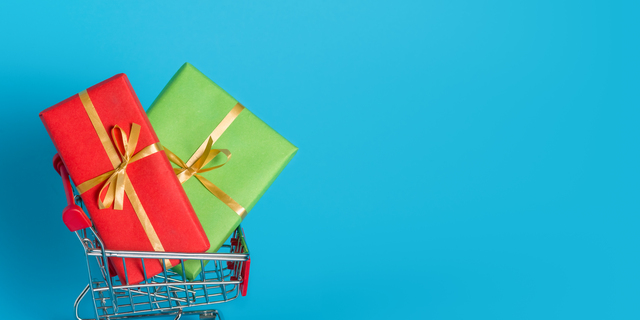 Buy holiday gifts in stores for Valentines Day or International Womens Day on March. Boxes in multi-colored paper with ribbons in a shopping cart