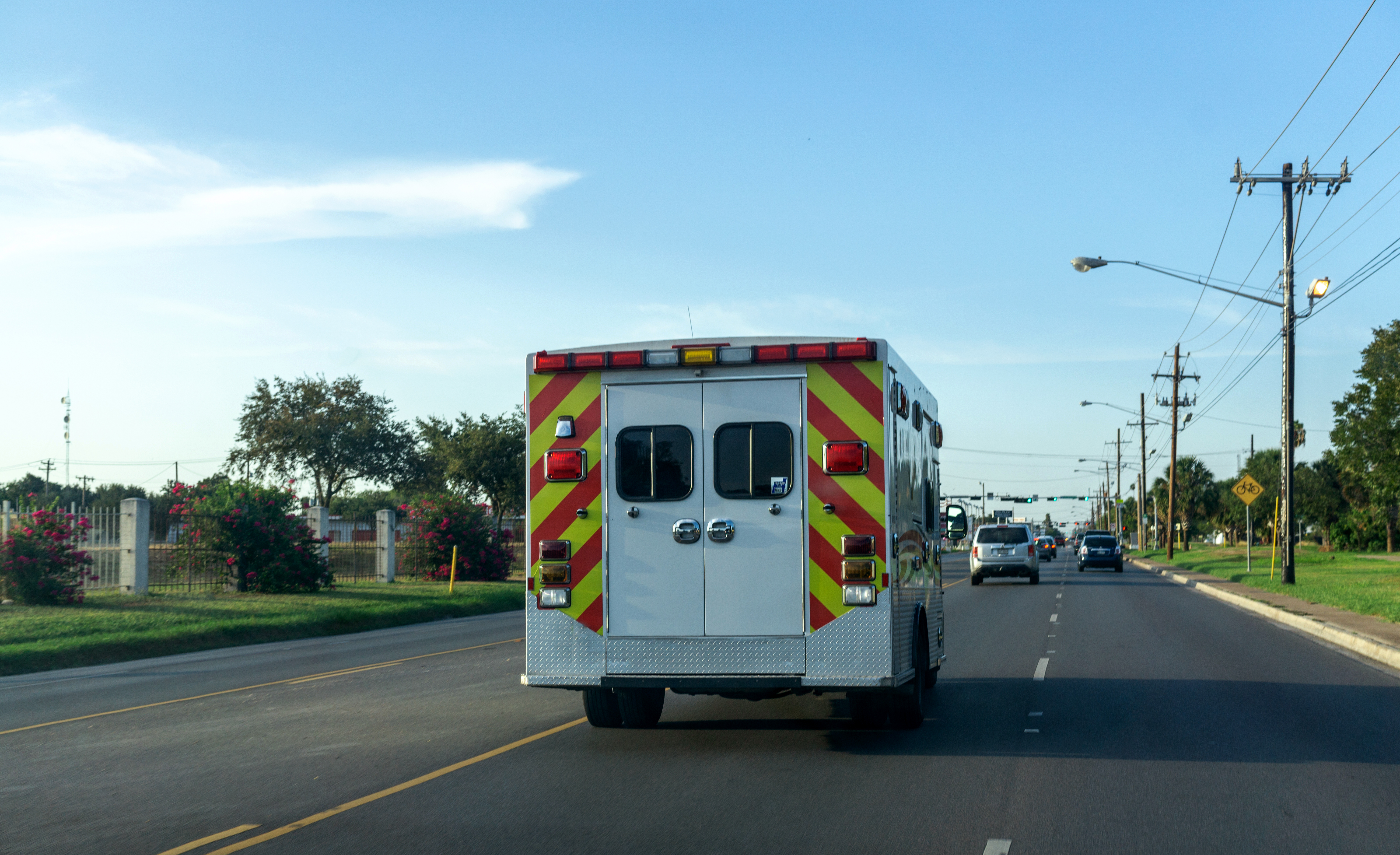 An emergency medical response vehicle drives down a road on a clear day.