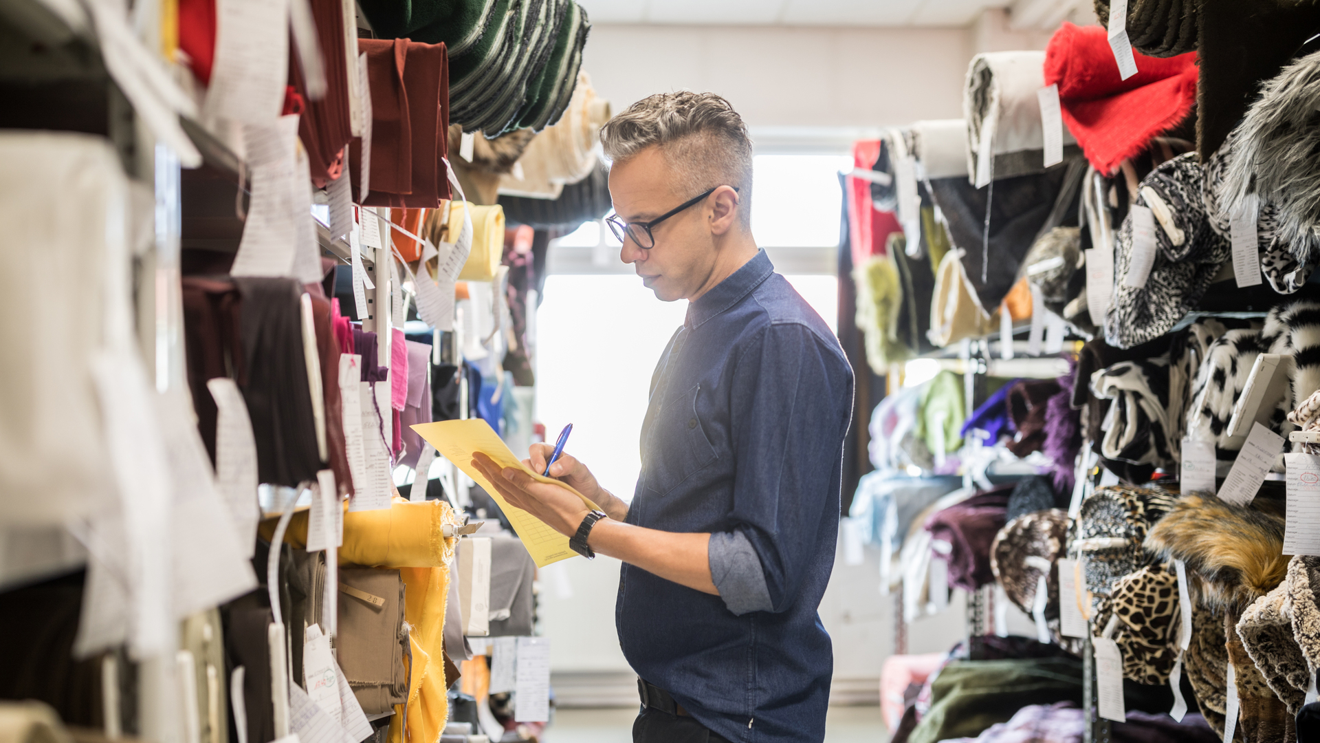 Textile shop owner verifying the stock