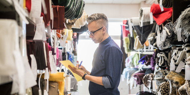 Textile shop owner verifying the stock