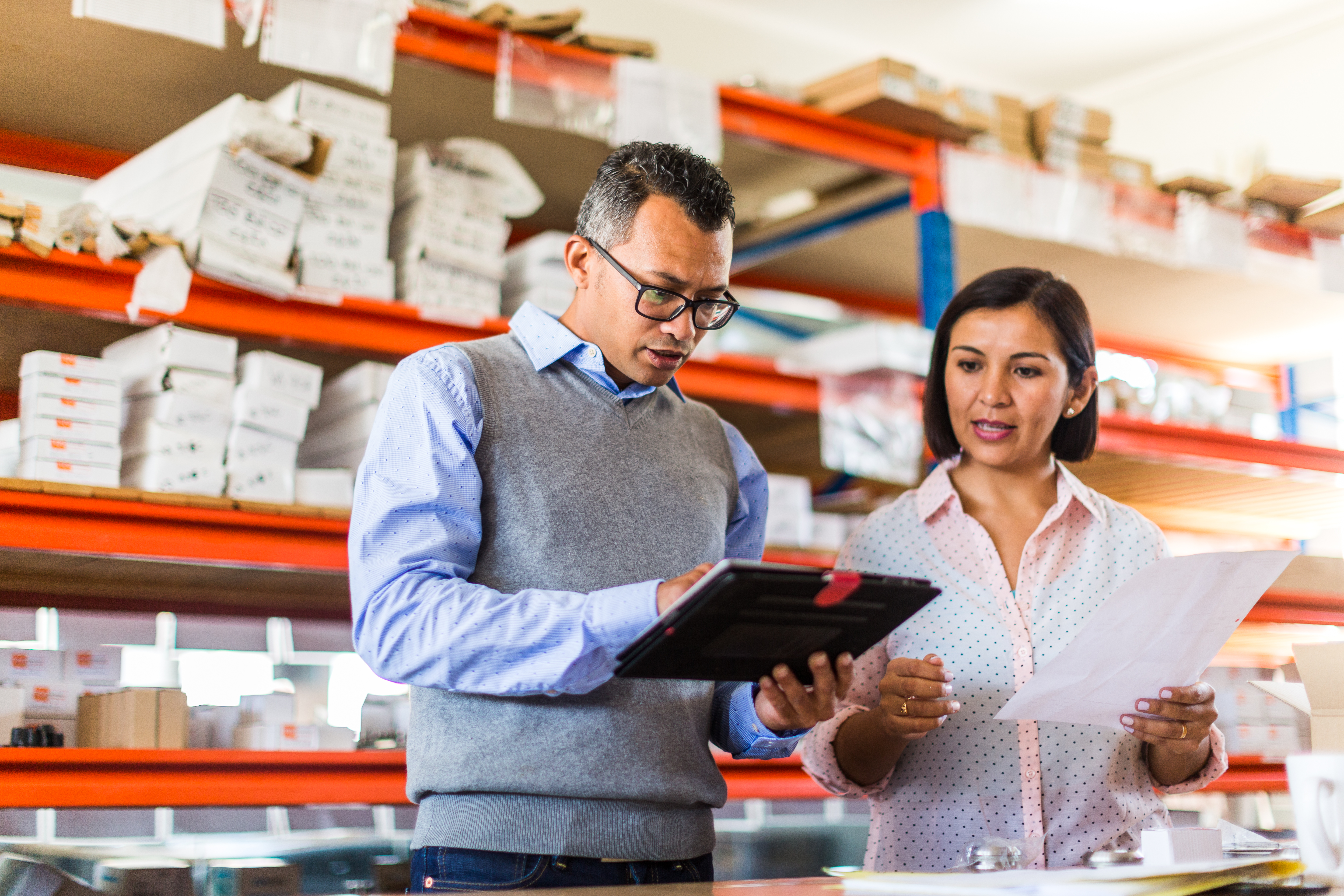 A man in a shipping facility uses enterprise computing solutions to manage inventory.