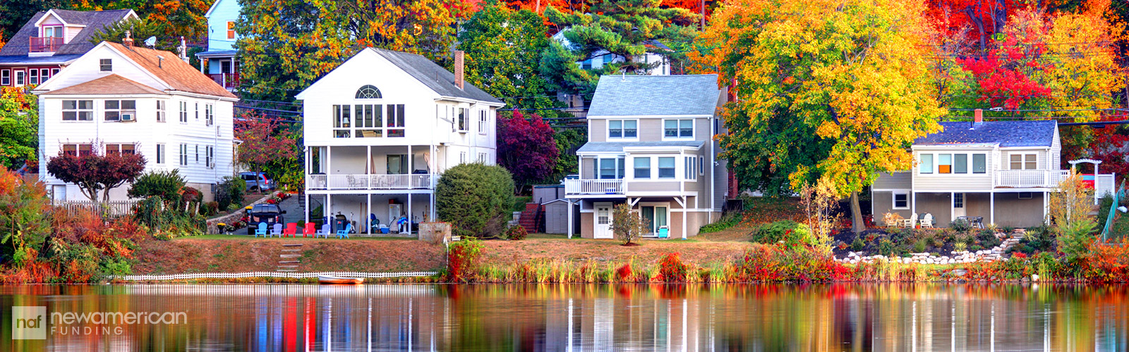 houses on a lakeside surrounded by vibrant-colored trees