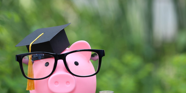 Graduation hat on pink piggy bank with stack of coins money on nature green background, Saving money for education concept