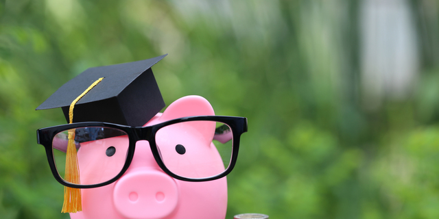 Graduation hat on pink piggy bank with stack of coins money on nature green background, Saving money for education concept