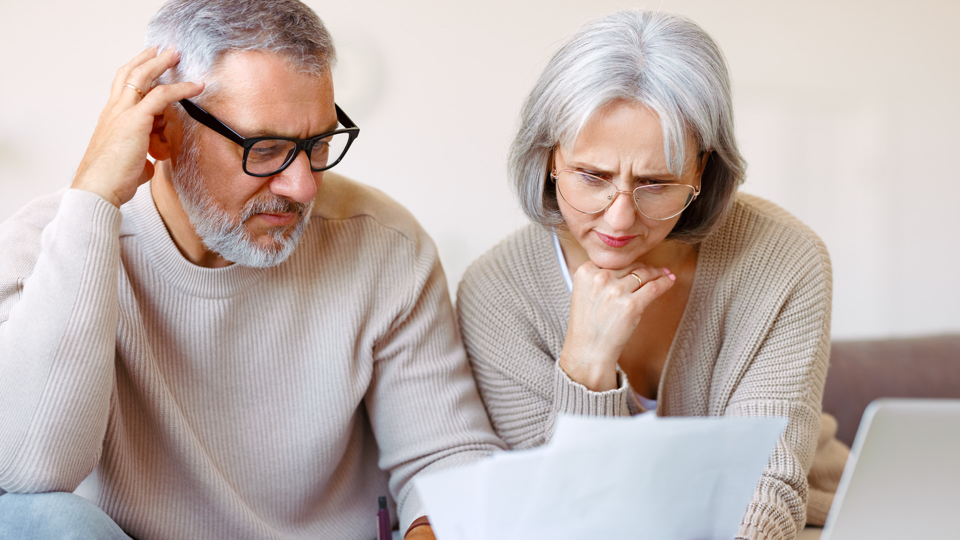 Worried senior family reading financial documents or notification letter with bad news from bank