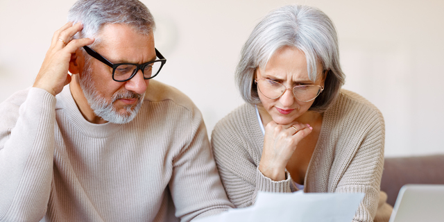 Worried senior family reading financial documents or notification letter with bad news from bank