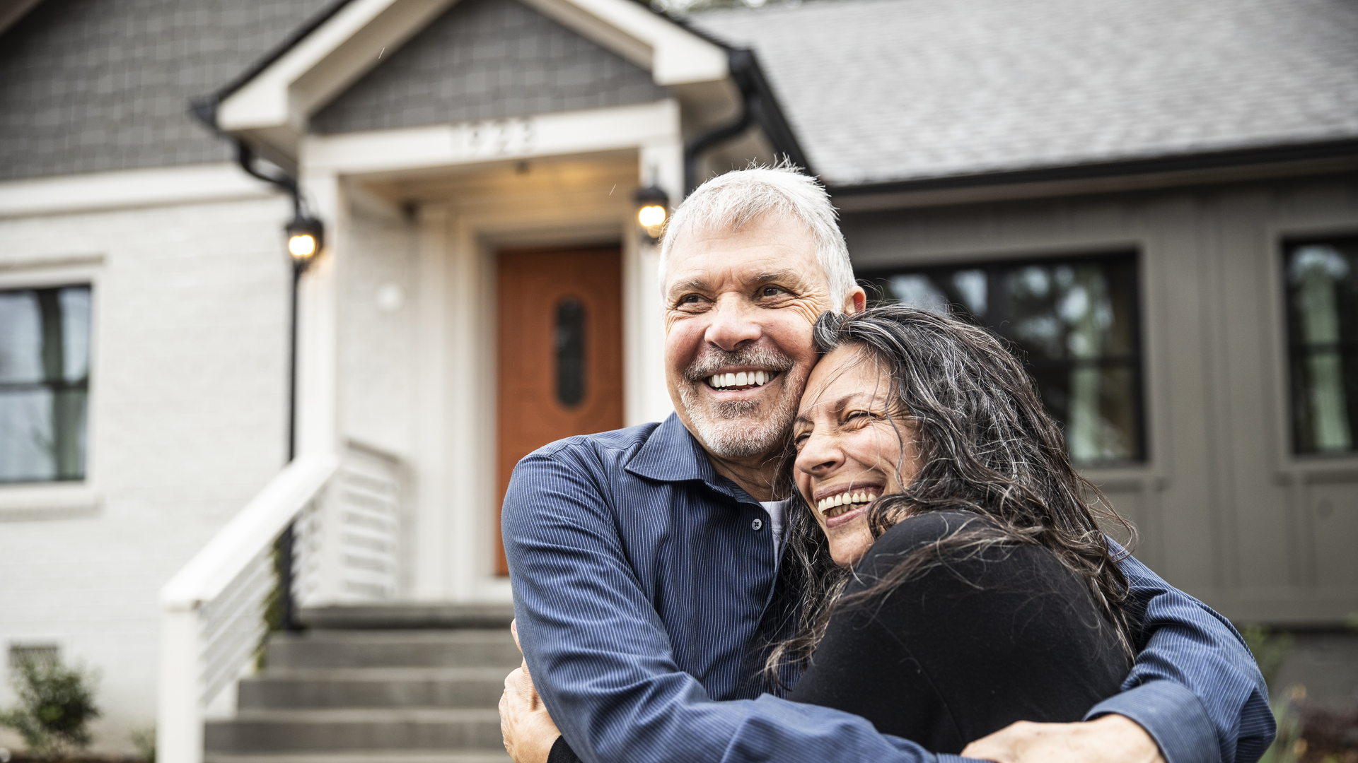 Portrait of senior couple in front of home