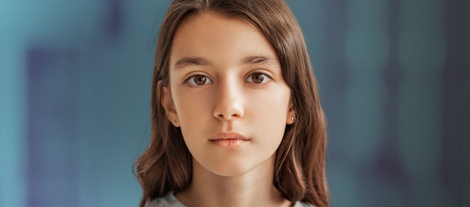 Tween girl looking at camera with blue background