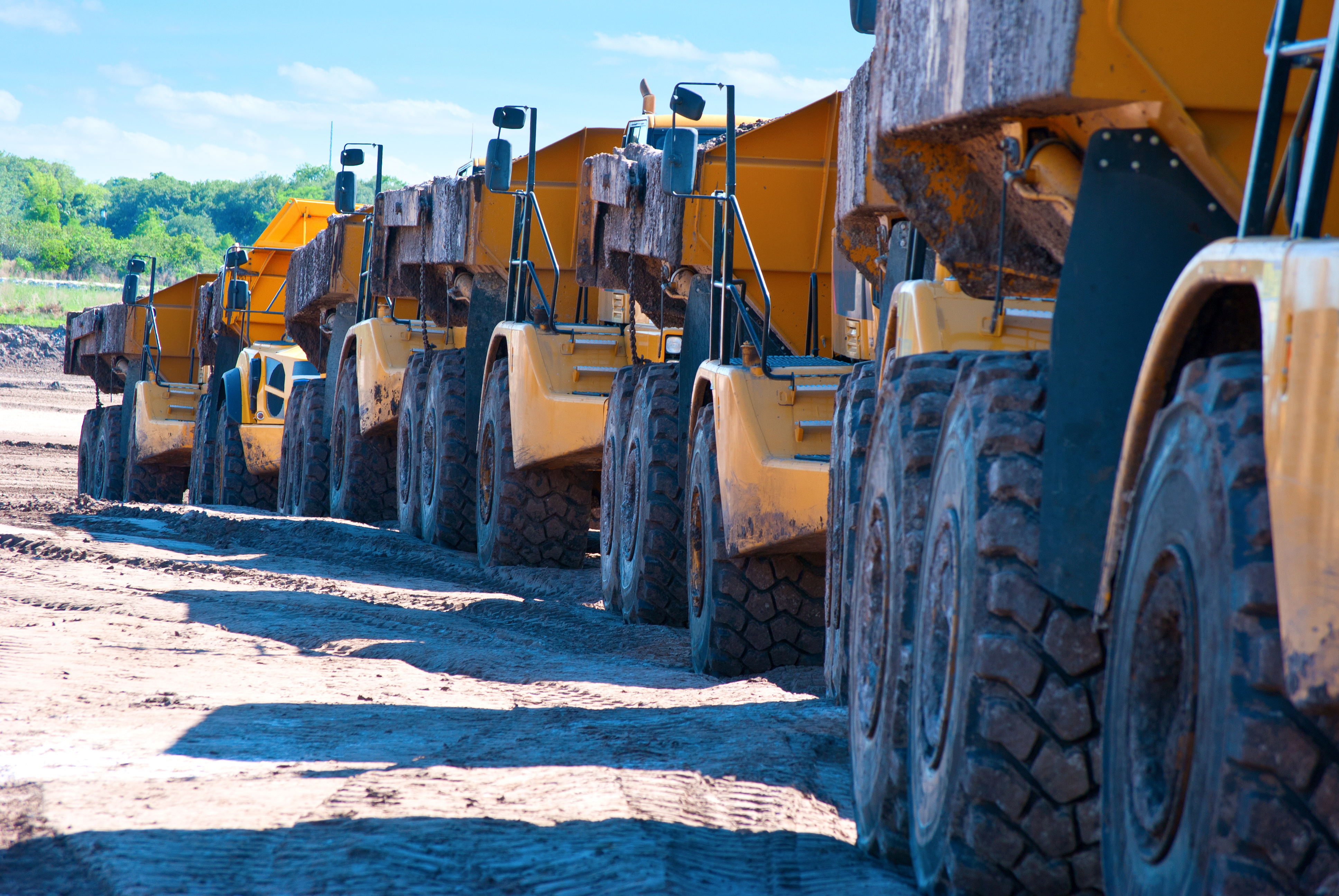 A line of construction vehicles is maintained through enterprise fleet management in the field.