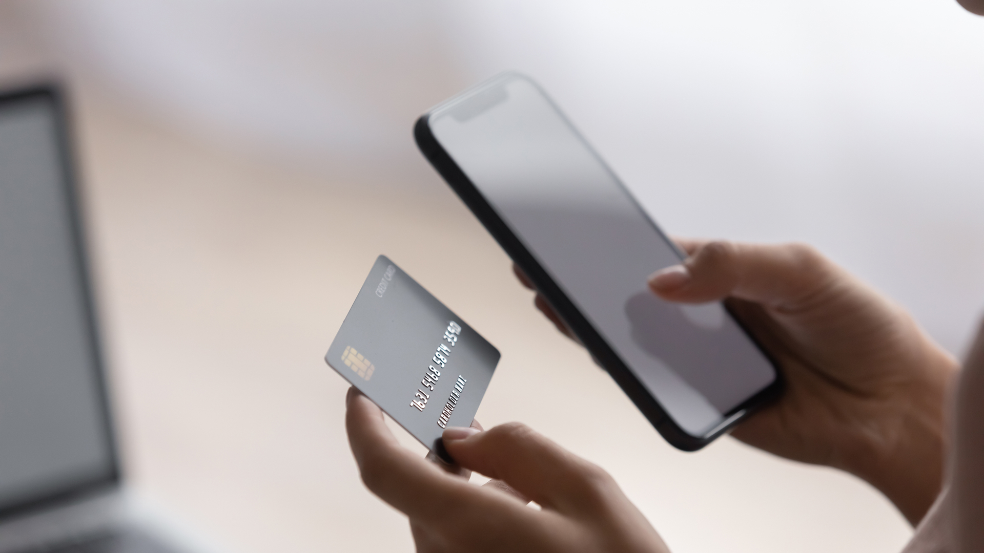 Female hands holding plastic card and cellphone purchasing goods online