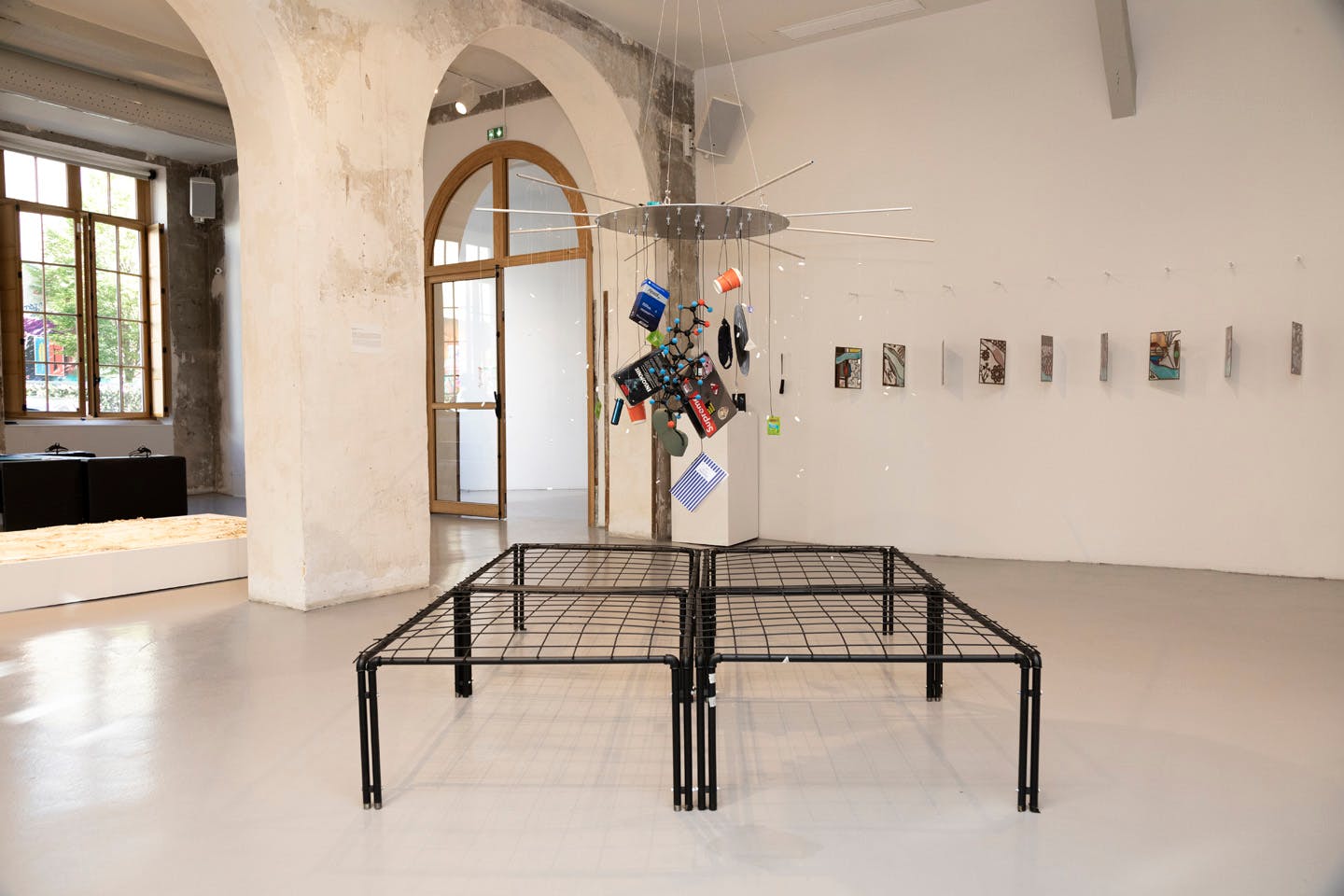 Hanging mixed-media installation with suspended objects in gallery space