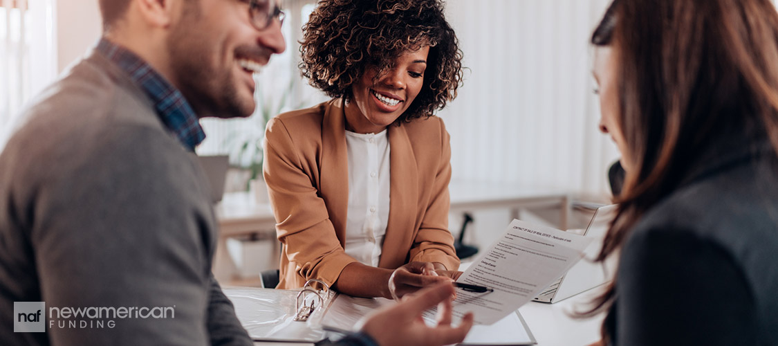 agent going over paperwork with happy clients