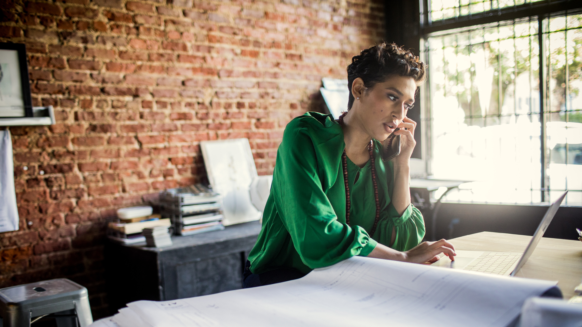 Businesswoman looking over architecture blueprints in office