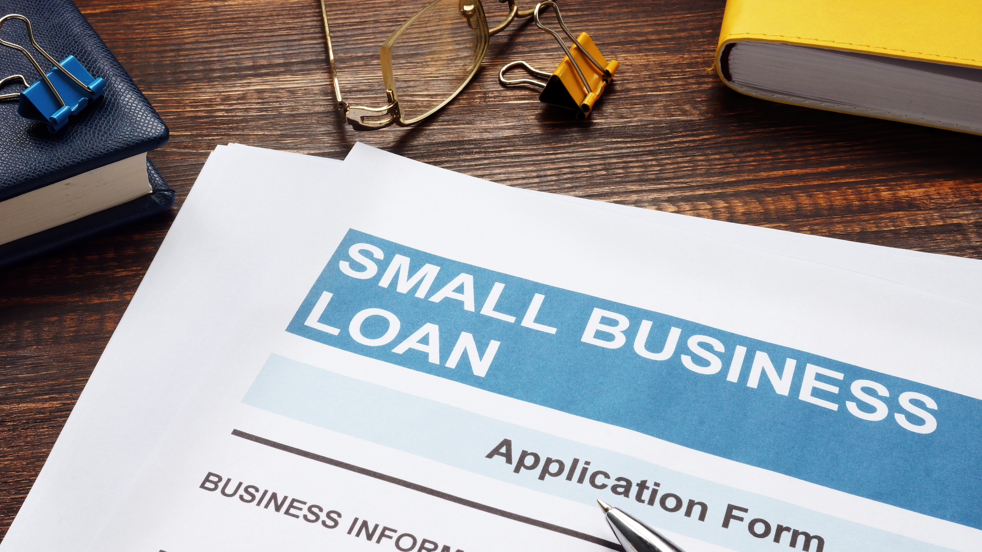 Small business loan application on the wooden surface and papers.