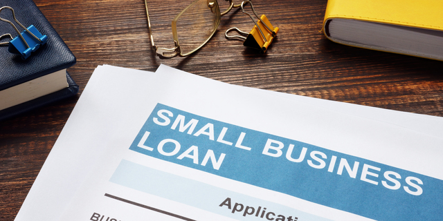 Small business loan application on the wooden surface and papers.