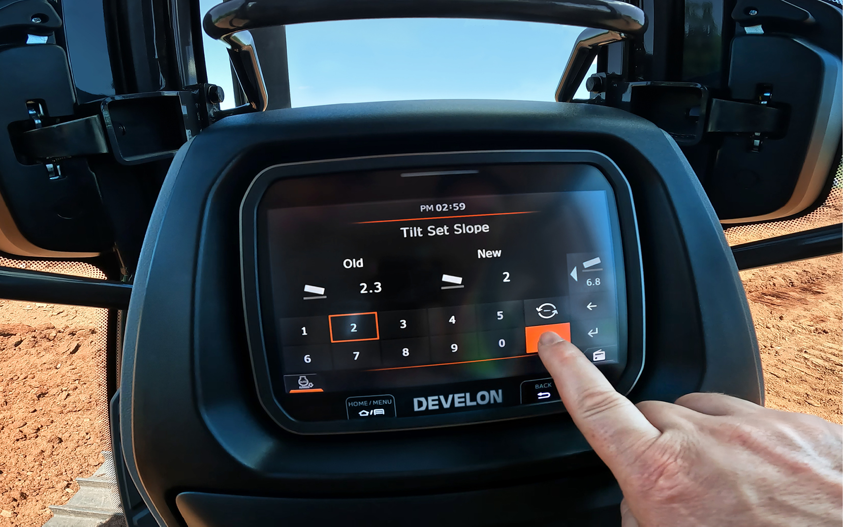 A dozer operator configures the 2D grading system on the LCD monitor in the cab.