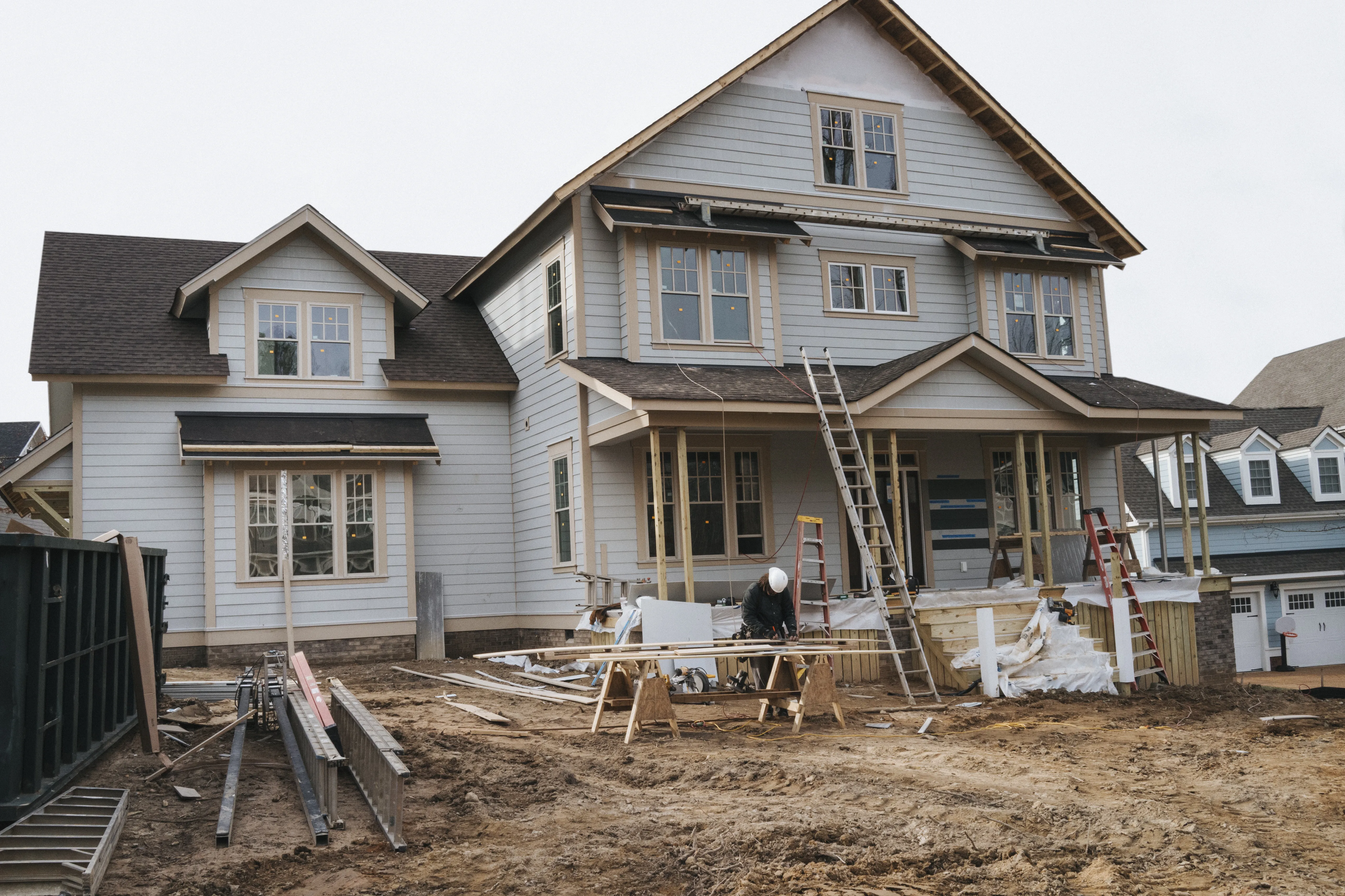 Contractors at a construction site, working on the exterior of a house.  