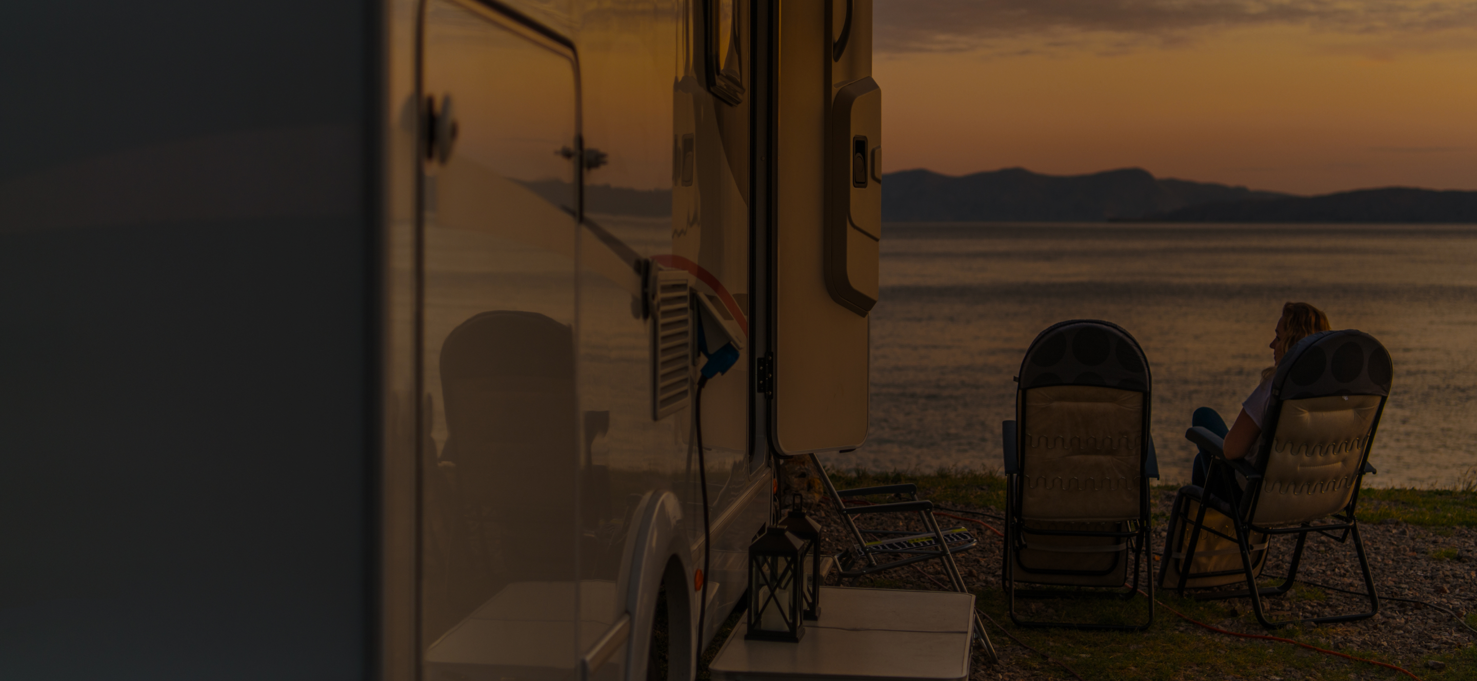 An RV parked up with a power cable connected