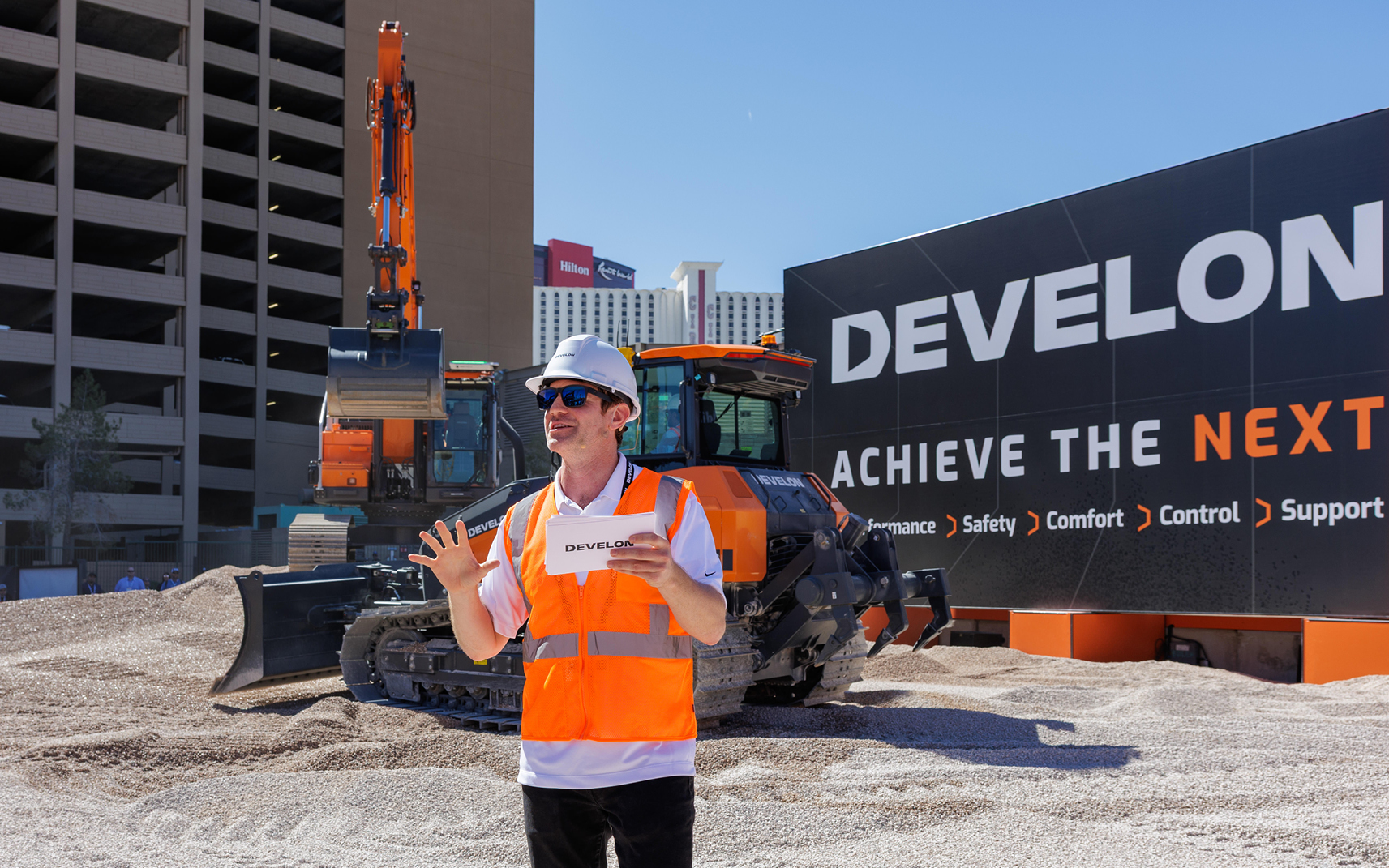 The emcee in the DEVELON demo pit at CONEXPO-CON/AGG explains the machines&rsquo; safety features.