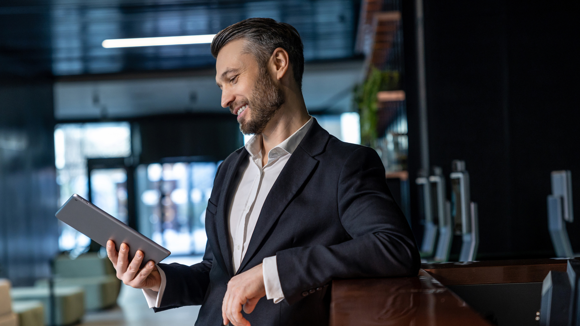 Man reading something online on a tablet and looking interested
