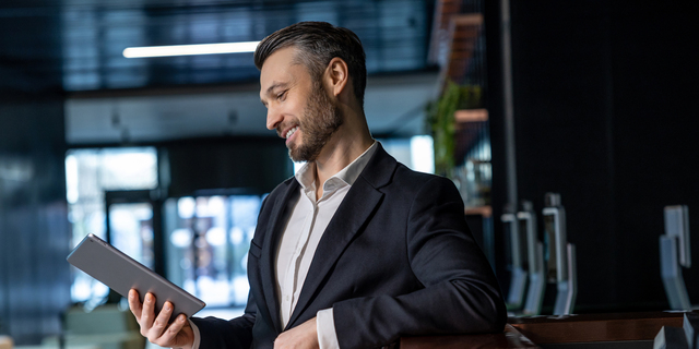Man reading something online on a tablet and looking interested