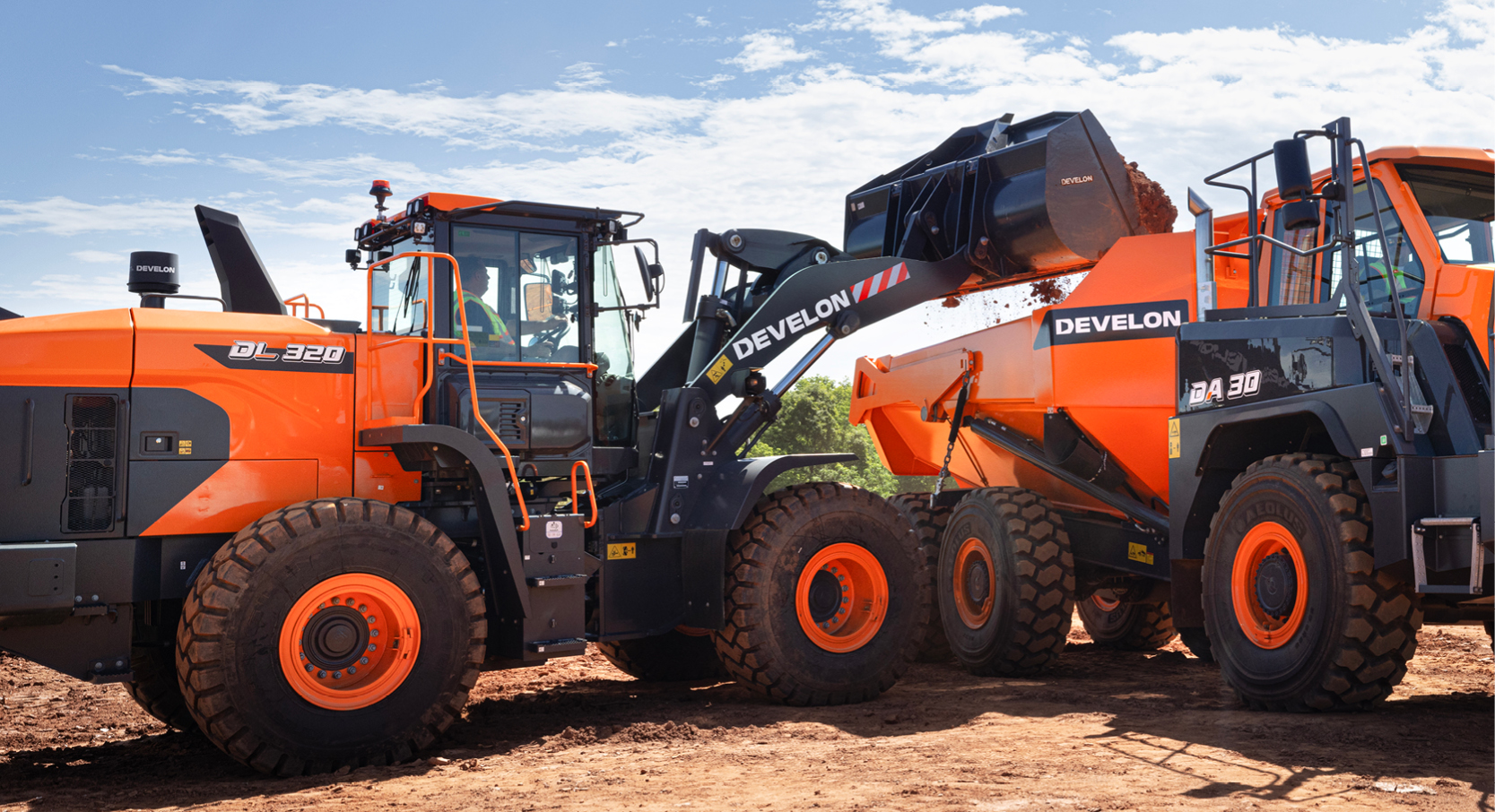 A DEVELON wheel loader scoops a large bucket of dirt into the back of a DEVELON ADT.