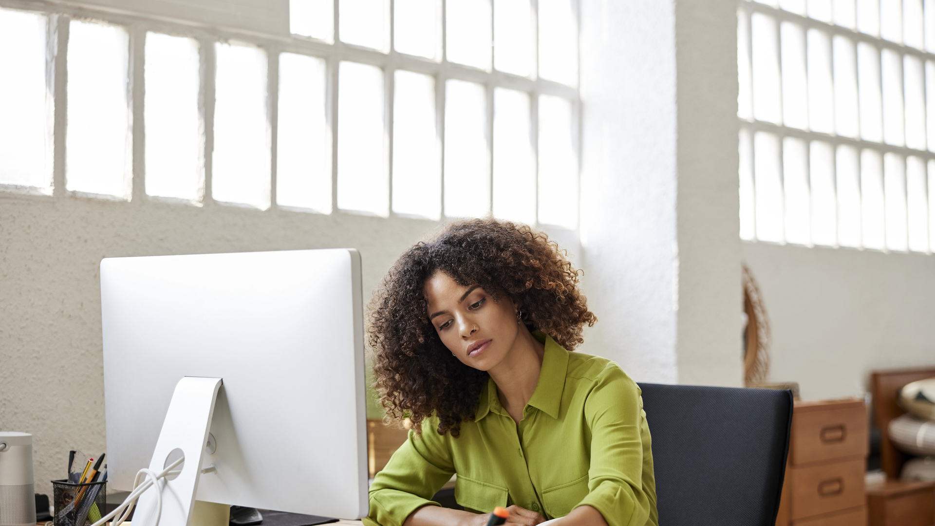 Businesswoman Writing On Document Sitting At Desk