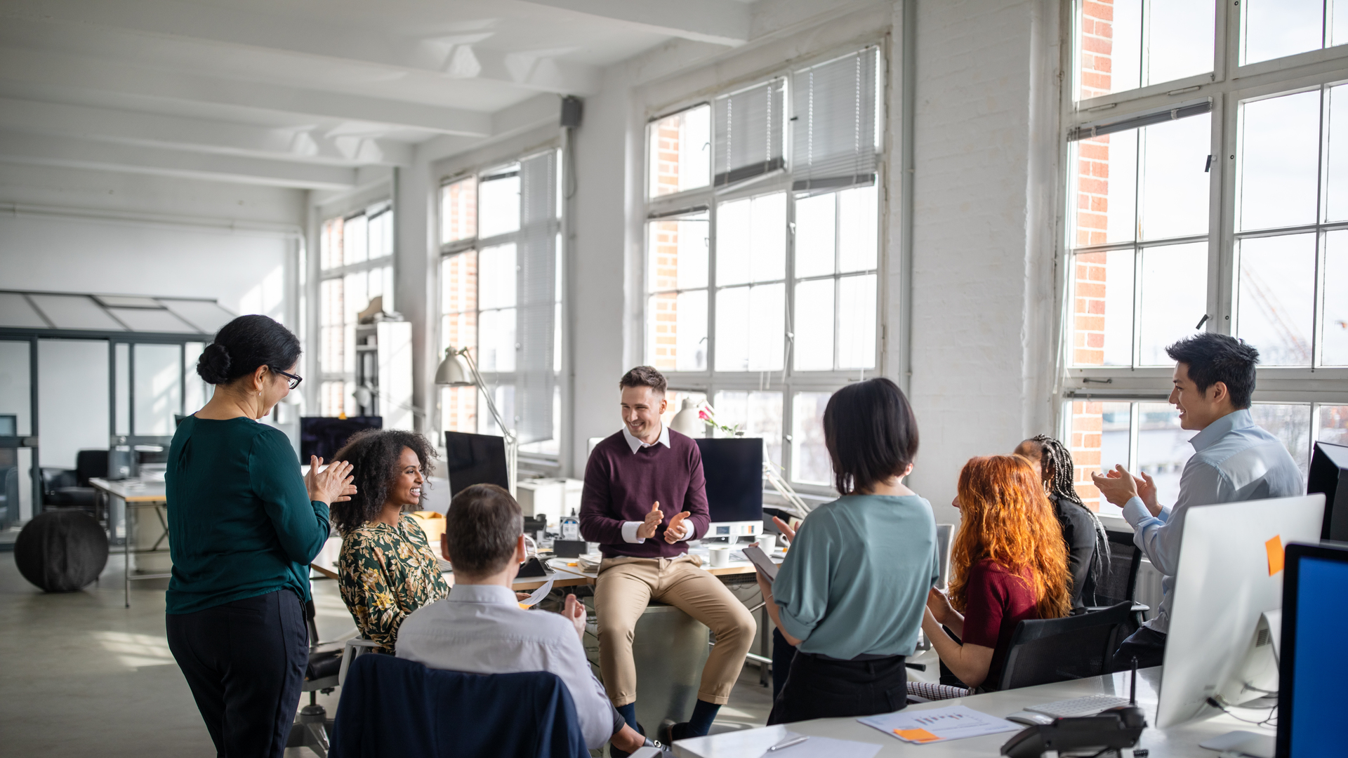 Business team clapping for a female colleague in meeting