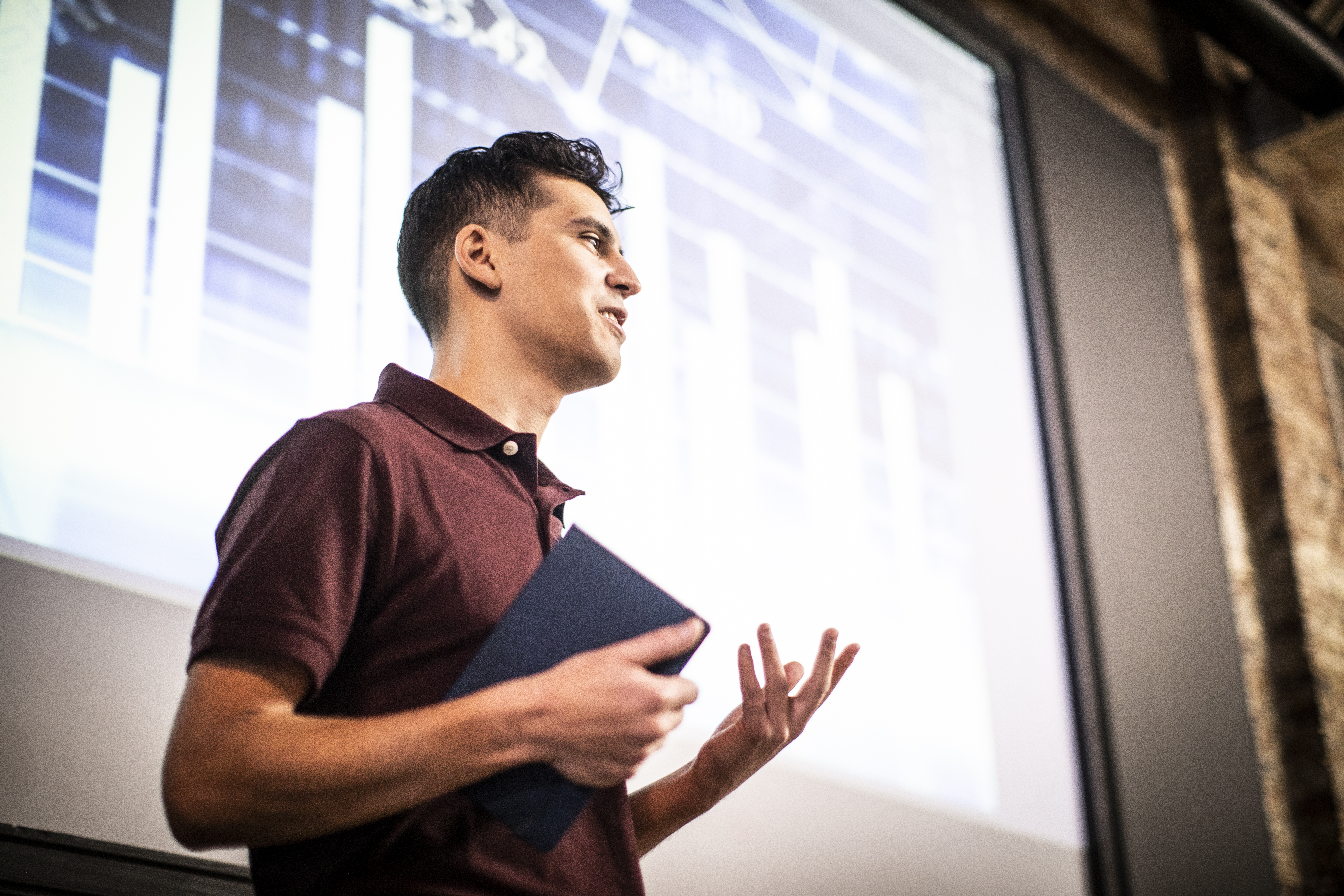 A man using a wireless presentation system to connect remotely to coworkers.