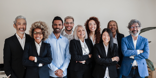 Multi-ethnic generational modern office: Successful business team smiling on camera - Focus on Asian girl face