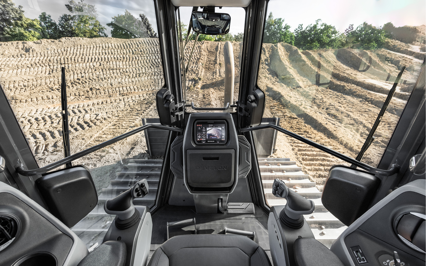 The operator cab of a DEVELON dozer featuring its visibility and various operator comfort features.