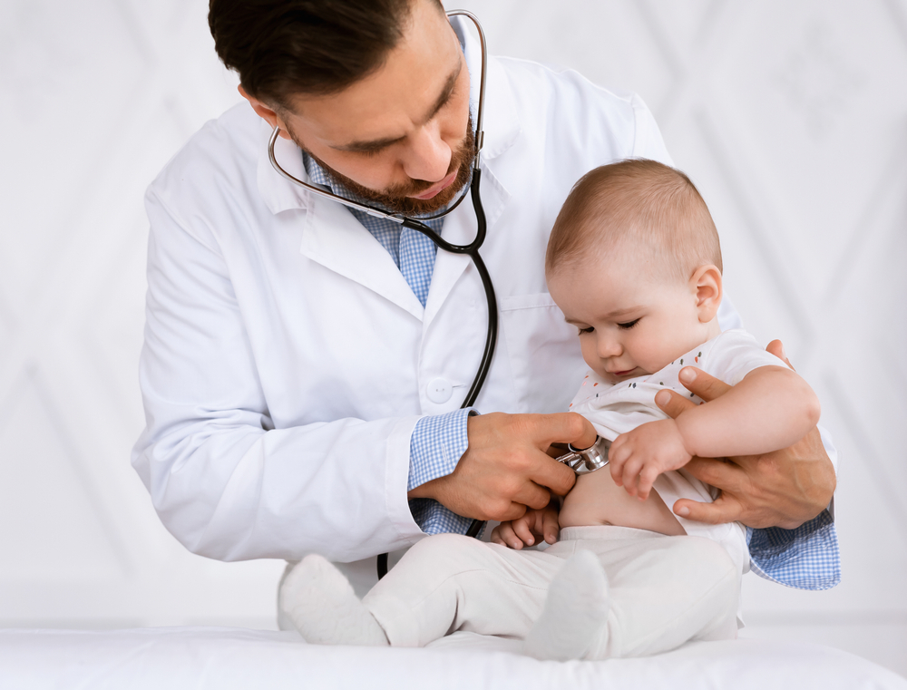 A doctor examines a baby with a stethoscope 