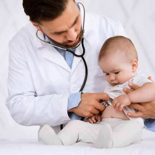 A doctor examines a baby with a stethoscope 