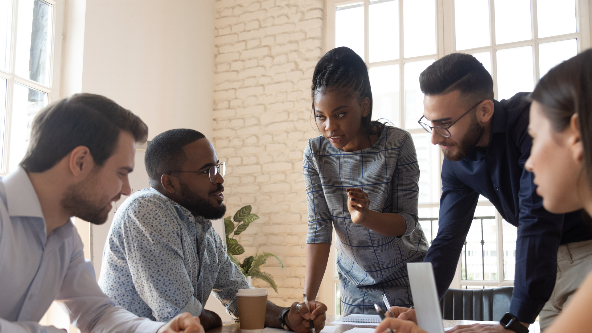 Serious multiracial corporate business team discuss paperwork at group briefing