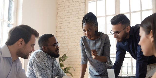 Serious multiracial corporate business team discuss paperwork at group briefing