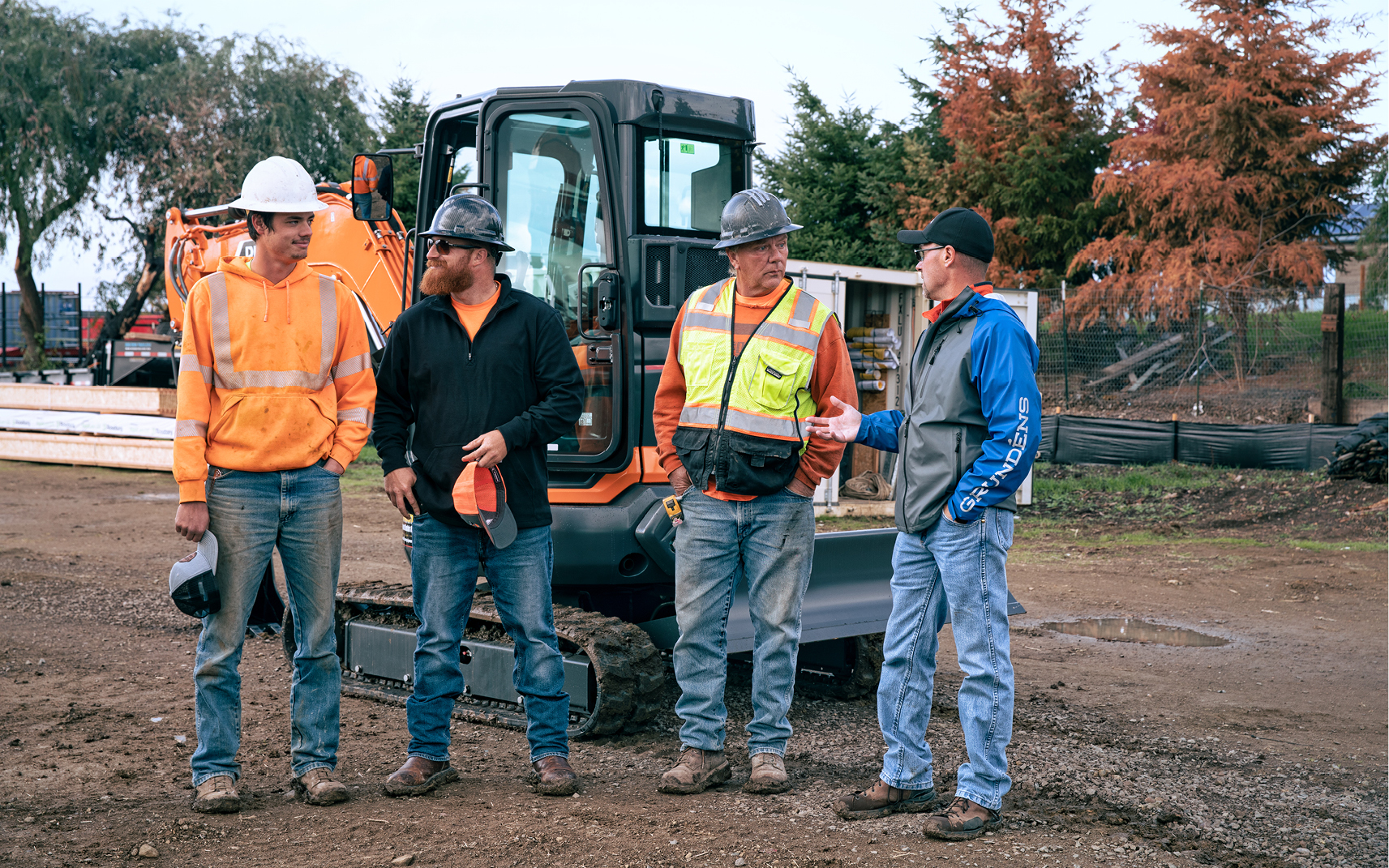 Heavy equipment operators having a conversation on a construction job site.