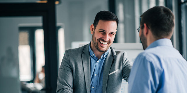 Portrait of cheerful young manager handshake with new employee.