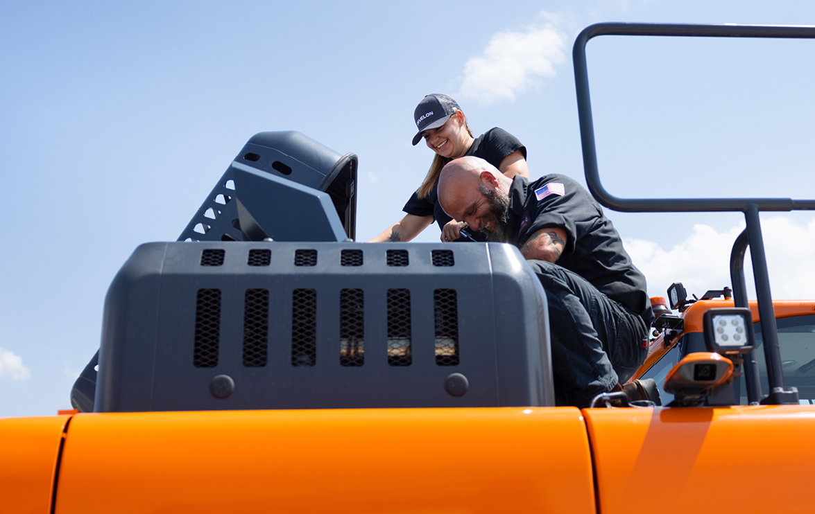 Equipment technicians perform planned maintenance on a DEVELON machine.