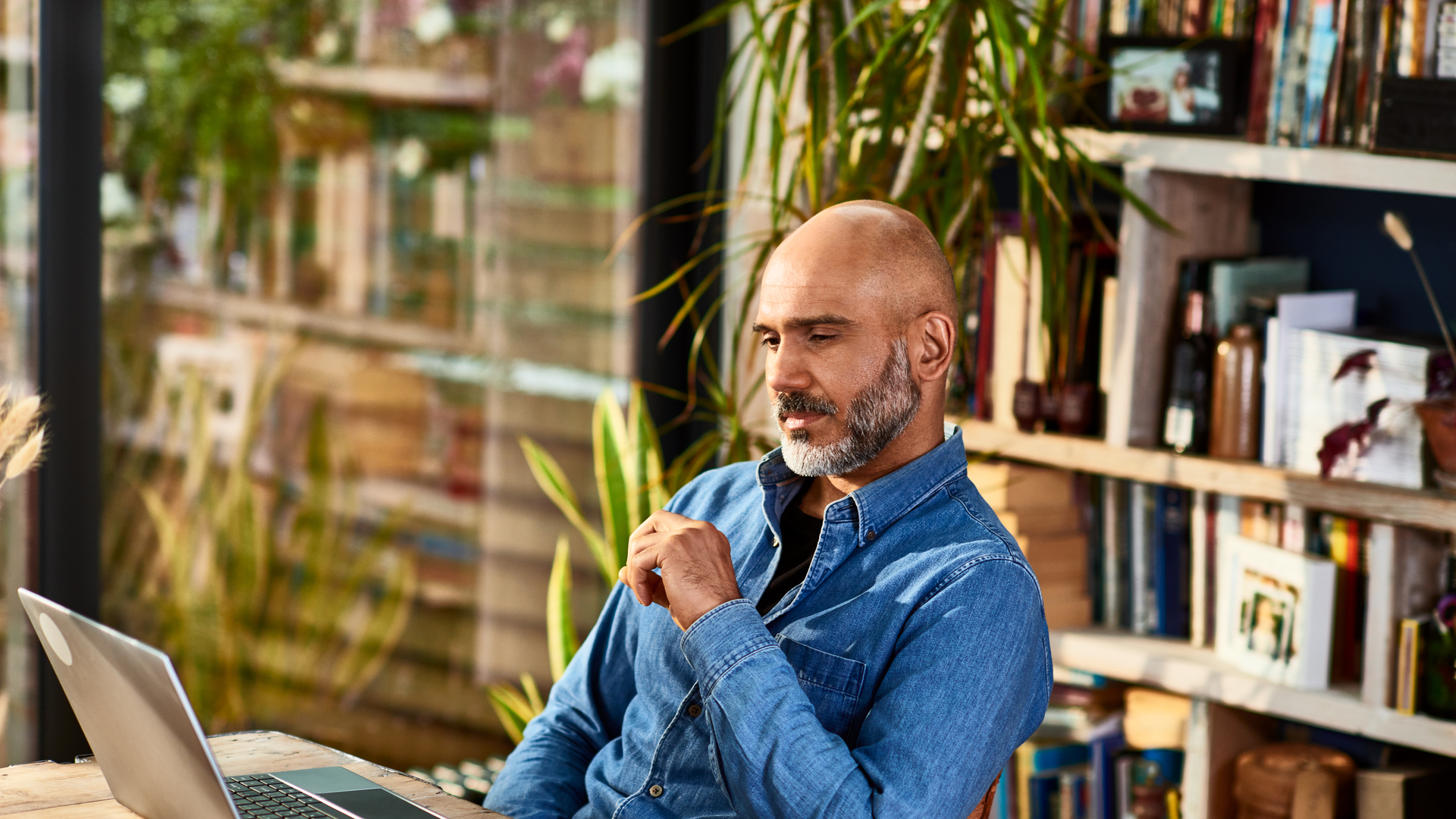 Mature businessman sitting at home watching laptop