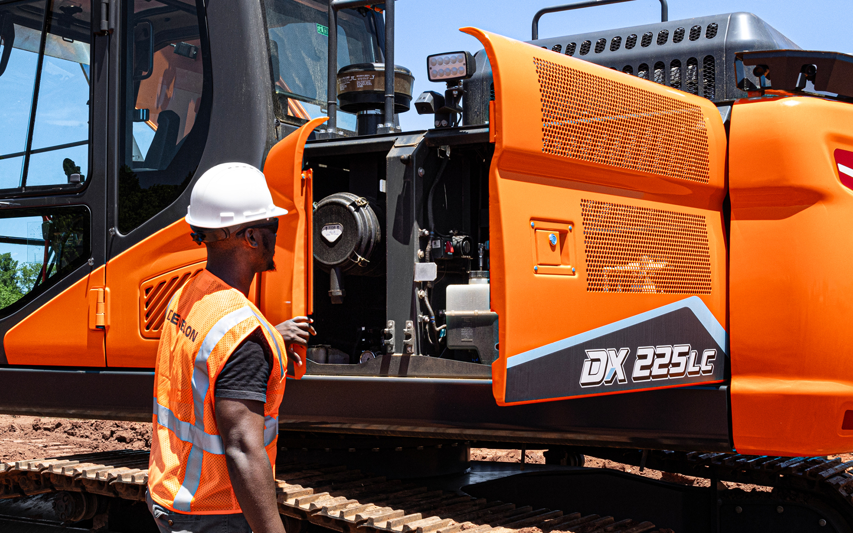 An operator following scheduled OEM maintenance and looking at the internal components on a DEVELON crawler excavator.
