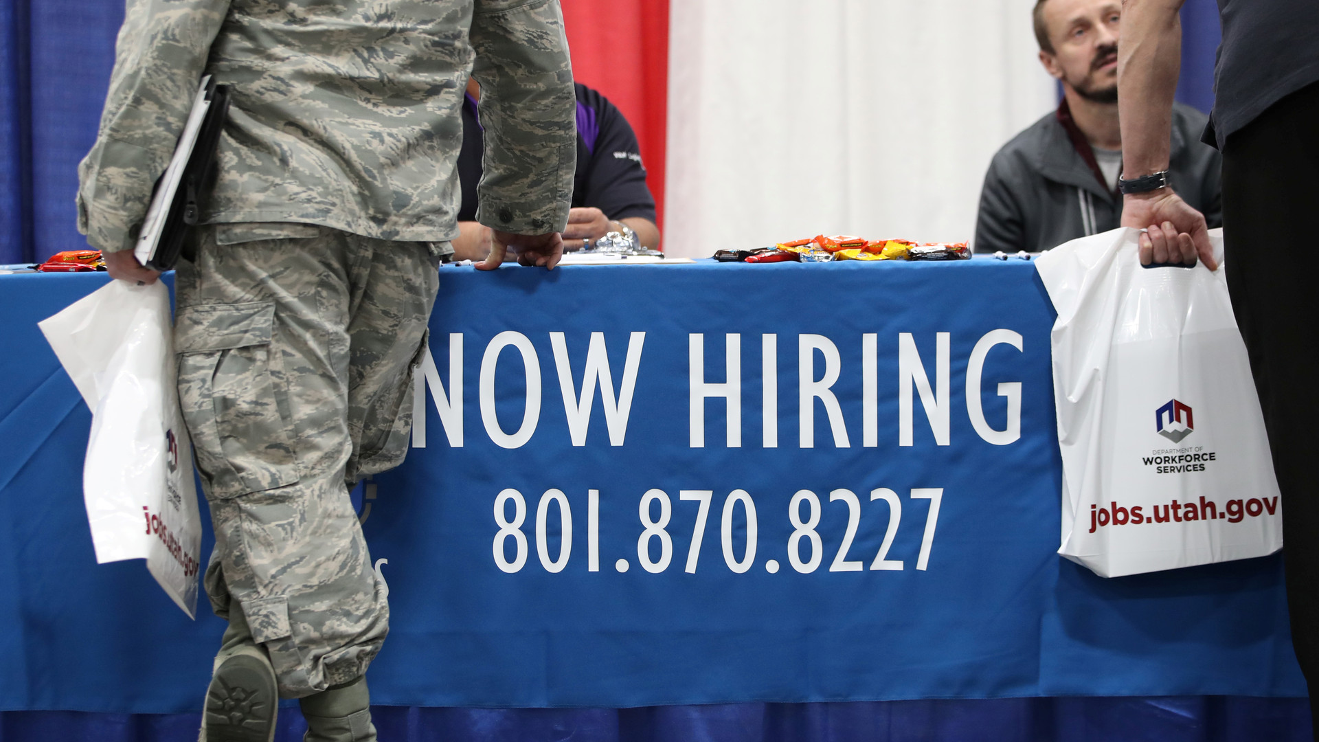 Veterans and military personnel discuss job opportunities at a military job fair in Sandy, Utah